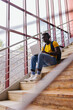 © VICTOR TORRES/Stocksy - Young man with laptop on stairs