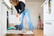 © Guille Faingold/Stocksy - Housewife filling the dishwasher in kitchen.