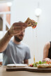 © Mal de Ojo Studio/Stocksy - Man picking up a pizza slice