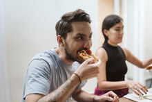 Man Taking A Big Bit Out Of A Pizza Slice