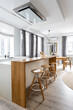 © Luciano Spinelli/Stocksy - Bright white large kitchen in a modern, minimalist design with a hood