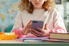 Crop Schoolgirl Browsing Social Media On Cellphone