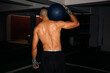 © Ángela Rober/Stocksy - View of the back of a strong man holding a fitness ball