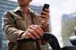 © Alba Vitta/Stocksy - Cropped man with phone and bike at city