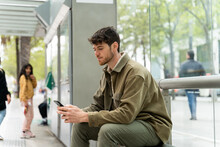 Man With Mobile Phone Waiting For Tram