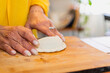 © Shava Cueva/Stocksy - Hands kneading flour to make empanadas on a wooden chopping board