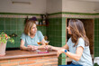 © Albert Martinez/Stocksy - Happy mother and daughter gossiping in kitchen