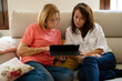 © Albert Martinez/Stocksy - Daughter teaching her mother to use the tablet
