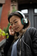 © Lauren Lee/Stocksy - Woman listening to headphones
