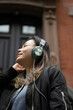 © Lauren Lee/Stocksy - Woman wearing headphones and smiling