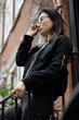 © Lauren Lee/Stocksy - Woman in glasses on stoop