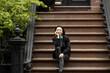 © Lauren Lee/Stocksy - Woman sitting on her stoop