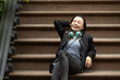 © Lauren Lee/Stocksy - Woman relaxing with headphones on stoop