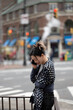 © Lauren Lee/Stocksy - Woman on the phone in the city