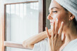 © Berena Alvarez/Stocksy - Woman Applying  cream On Face
