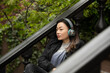© Lauren Lee/Stocksy - Woman with headphones on stoop