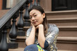 © Lauren Lee/Stocksy - Woman sitting on stoop