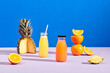 © Marc Tran/Stocksy - Fresh orange and pineapple juice in bottles with fresh ingredients