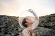© Luis Velasco/Stocksy - Art Portrait Of A Girl With Dress And Bubble Helmet In The Desert.