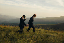 Stylish Couple In Black Suits On A Walk Among Mountain Landscapes