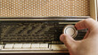 © Nasos Zovoilis/Stocksy - Close up of man hands adjusting frequency on vintage radio with knob