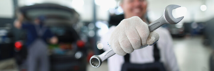 Wall Mural - Car maintenance service worker holding wrench equipment for work