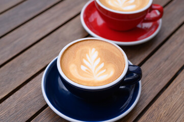 Cups of aromatic coffee on wooden table, closeup