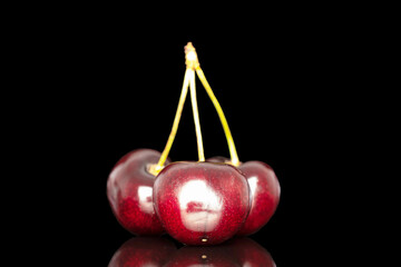 Three sweet cherries, close-up, isolated on a black background.