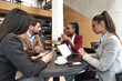 © Srdjan - Group of young business freelancers people sitting in cafeteria on staff meeting discussing about future of their company. Colleagues having conversation about hiring new employee. Selective focus