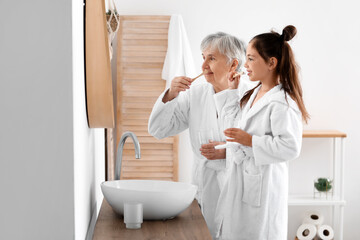 Canvas Print - Little girl and her grandma brushing teeth in bathroom