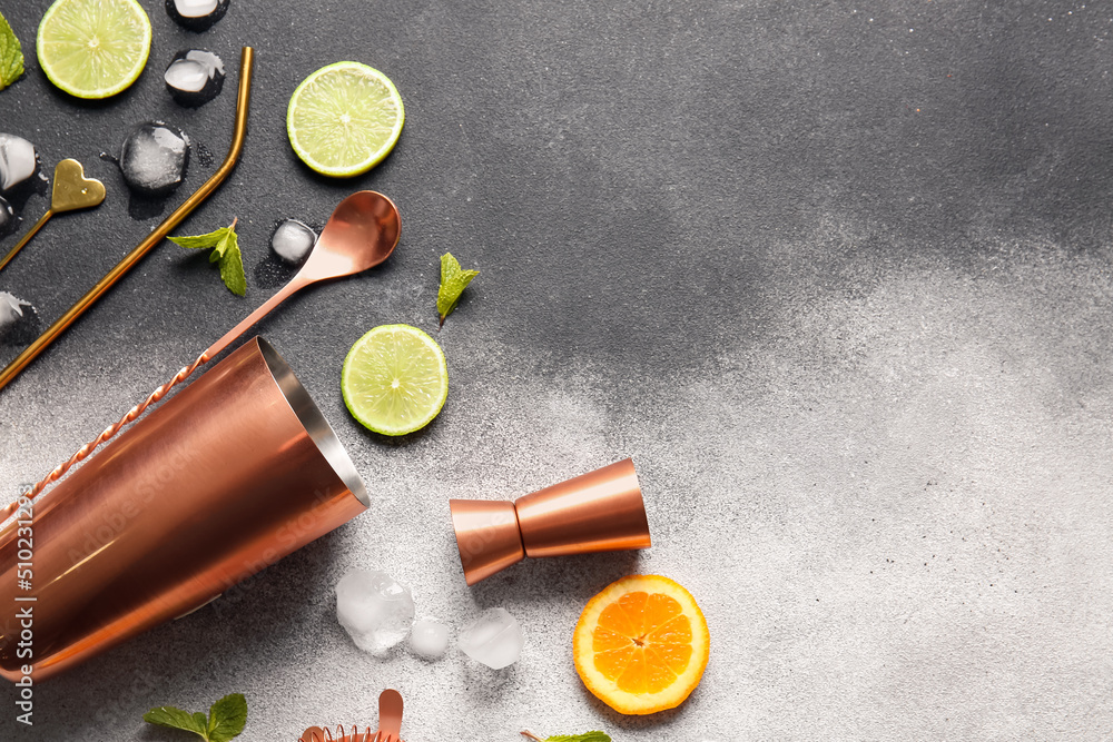 Different bartender tools and cocktail ingredients on black and white background