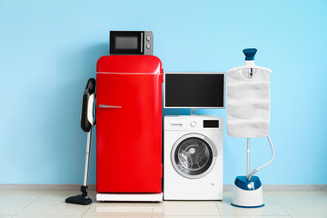 Wall Mural - Modern household appliances near blue wall in room