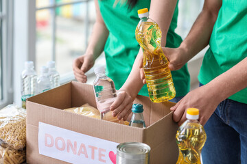 Wall Mural - Polish volunteers putting bottles of sunflower oil and water into donation box for Ukraine in center, closeup