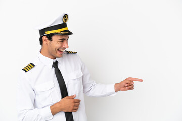 Wall Mural - Airplane pilot over isolated white background pointing finger to the side and presenting a product