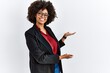 © Krakenimages.com - African american woman with afro hair wearing business jacket and glasses inviting to enter smiling natural with open hand