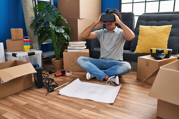 Sticker - Young hispanic man suprised using virtual reality glasses at new home