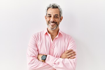 Canvas Print - Middle age hispanic man standing over isolated background happy face smiling with crossed arms looking at the camera. positive person.