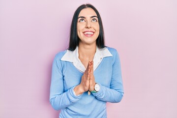 Sticker - Beautiful woman with blue eyes standing over pink background begging and praying with hands together with hope expression on face very emotional and worried. begging.