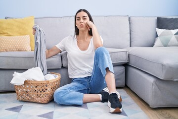 Wall Mural - Young brunette woman doing laundry at home looking at the camera blowing a kiss being lovely and sexy. love expression.