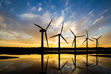 windmills in water. wind farm next to river. windmills before sunset. green energy. windmills in eve