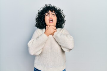 Poster - Young middle east woman wearing casual white tshirt shouting and suffocate because painful strangle. health problem. asphyxiate and suicide concept.