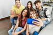 © Krakenimages.com - Group of young friends smiling happy make selfie by the smartphone sitting on the sofa at home.