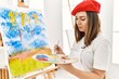 © Krakenimages.com - Young hispanic artist woman wearing french beret drawing at art studio.