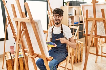 Poster - Hispanic man with beard at art studio smiling happy pointing with hand and finger