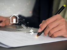 The Woman's Hand Is Signed On Paper, And The Home Sign Is Displayed On The Virtual Screen. Mortgage Payment And Reduction, Interest Calculation, Taxation, Savings, And Planning