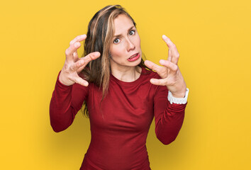 Canvas Print - Young blonde woman wearing casual clothes shouting frustrated with rage, hands trying to strangle, yelling mad