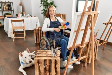 Sticker - Caucasian young blonde woman sitting on wheelchair at art studio looking positive and happy standing and smiling with a confident smile showing teeth