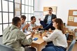 © Krakenimages.com - Businessman enjoys meditating during meeting. Sitting on desk near arguing partners at the office.