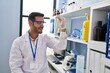 © Krakenimages.com - Young hispanic man scientist looking test tube at laboratory