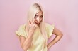© Krakenimages.com - Caucasian woman standing over pink background pointing to the eye watching you gesture, suspicious expression